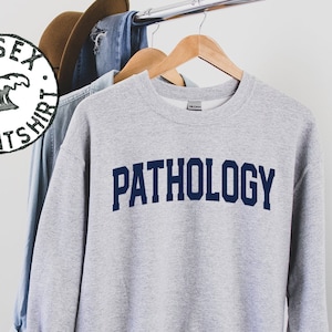 May include: Gray sweatshirt with the word "PATHOLOGY" printed in navy blue.