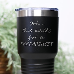 May include: Black stainless steel travel mug with a white inscription that reads "Ooh... this calls for a SPREADSHEET".