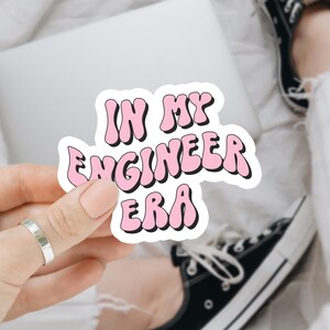 May include: Pink sticker with the text "IN MY ENGINEER ERA" in a wavy font.