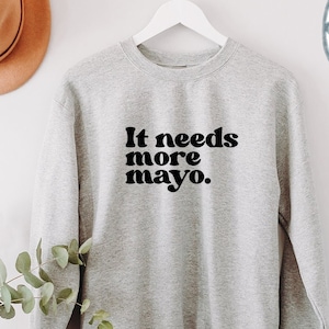Może przedstawiać: Szara bluza z nadrukiem "It needs more mayo." w kolorze czarnym.