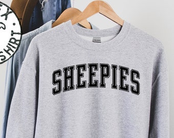 May include: A gray sweatshirt with the word "SHEEPIES" printed in black block letters.