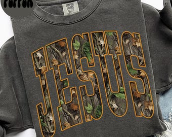 Puede incluir: Sudadera gris oscuro con la palabra "JESUS" en letras grandes. Las letras están rellenas con un patrón de camuflaje de hojas y ramas marrones, verdes y beige, delineadas en naranja. La palabra "PEPPER" está en un círculo negro.