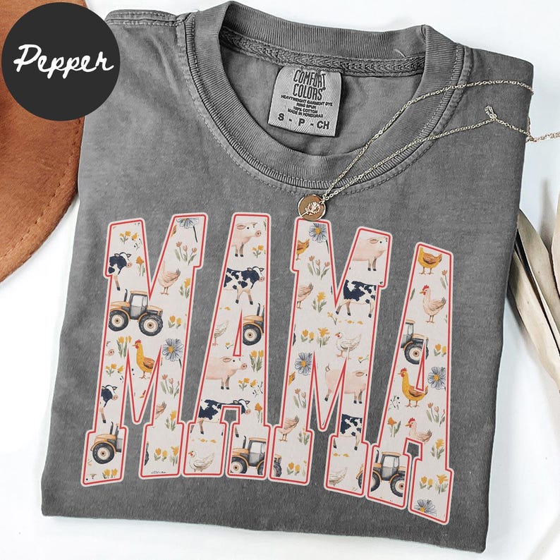 A gray t-shirt with the word "MAMA" printed on it, featuring various farm and animal-themed illustrations.