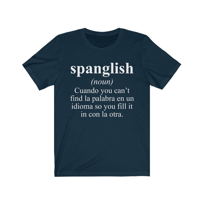 Puede incluir: Una camiseta azul marino con texto blanco que dice "spanglish (nombre) Cuando you can't find la palabra en un idioma so you fill it in con la otra."