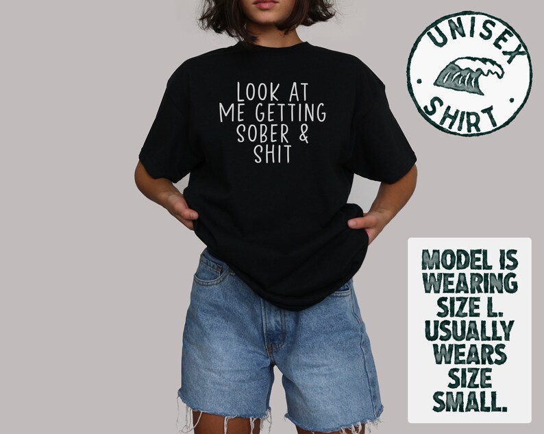 May include: Black t-shirt with white text that reads "Look at me getting sober & shit". The model is wearing a size L, but usually wears a size S.