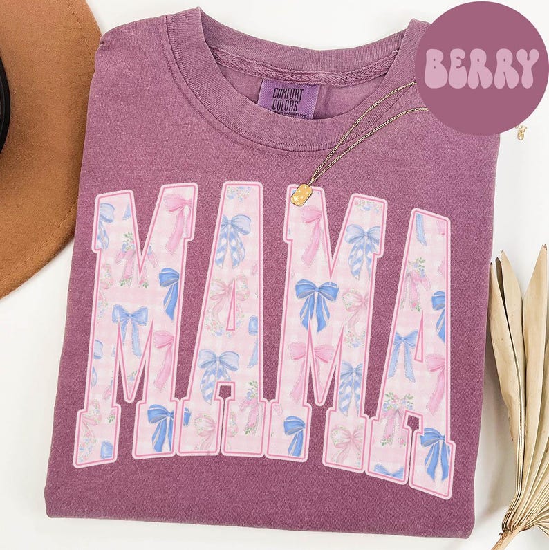 A purple t-shirt with the word "MAMA" printed in large letters, featuring a floral pattern in shades of pink and blue.