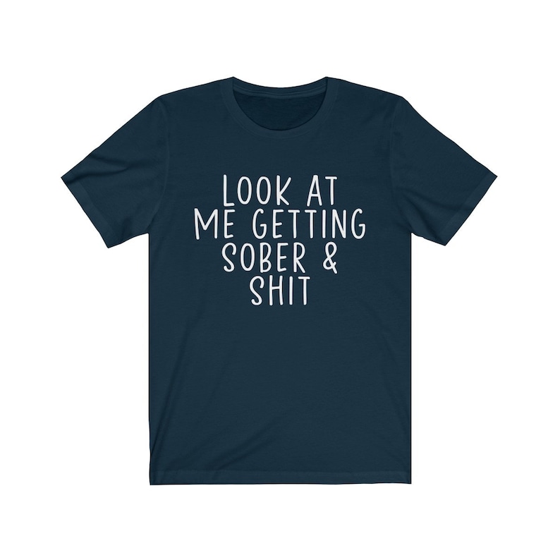 May include: A navy blue t-shirt with white text that reads "LOOK AT ME GETTING SOBER & SHIT".