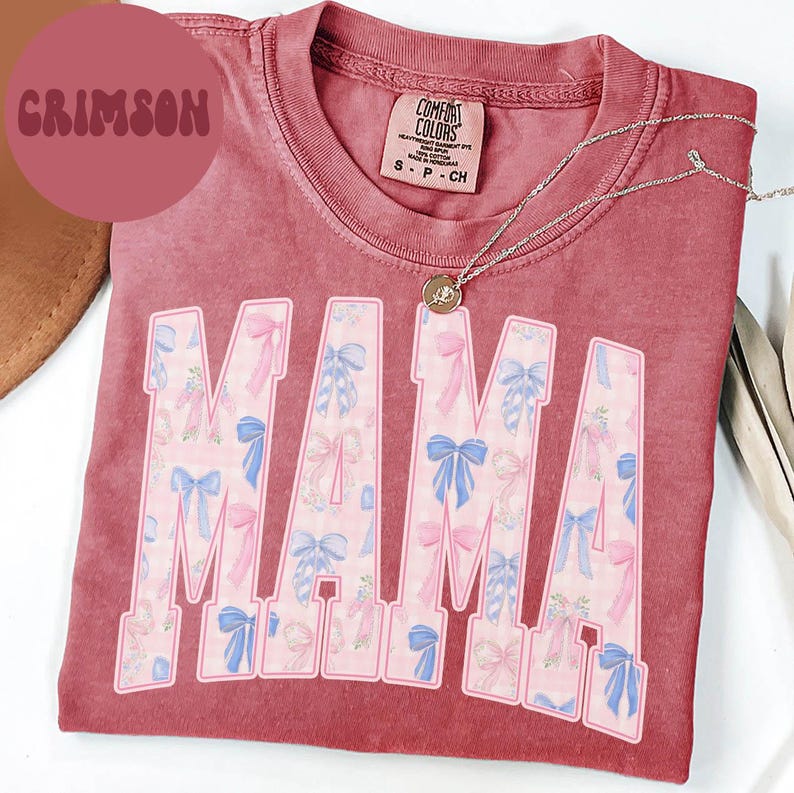 A pink t-shirt with the word "MAMA" printed in large letters, along with a necklace and a brown hat.