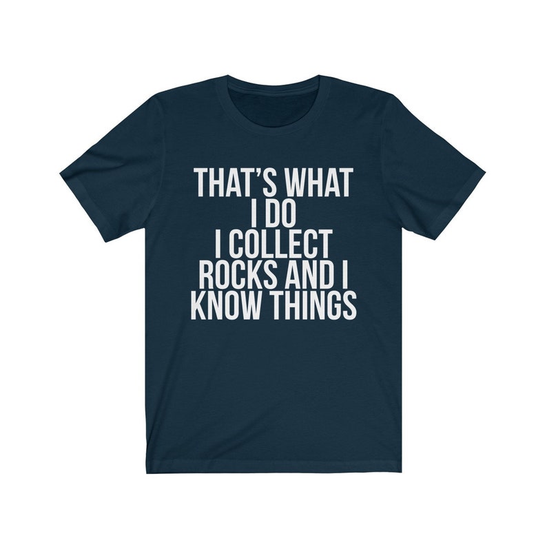 Puede incluir: Una camiseta azul marino con texto blanco que dice "That's what I do I collect rocks and I know things."