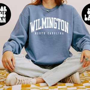 May include: A blue sweatshirt with the text "WILMINGTON NORTH CAROLINA" in white. The sweatshirt is a large size.