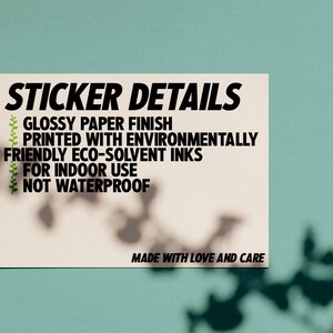 Peut inclure: Un autocollant blanc avec du texte noir qui indique "STICKER DETAILS" et liste les d&eacute;tails suivants : "Finition papier glac&eacute;", "Imprim&eacute; avec des encres &eacute;co-solvants respectueuses de l'environnement", "Pour une utilisation en int&eacute;rieur", "Non &eacute;tanche". L'autocollant comprend &eacute;galement le texte "Fabriqu&eacute; avec amour et soin".