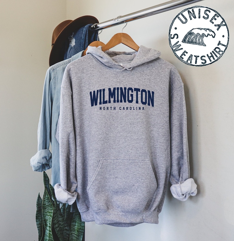 Puede incluir: Sudadera gris con capucha con el texto "WILMINGTON NORTH CAROLINA" en letras azules.