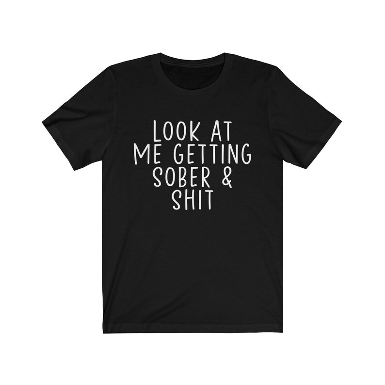May include: Black t-shirt with white text that reads "Look at me getting sober & shit."