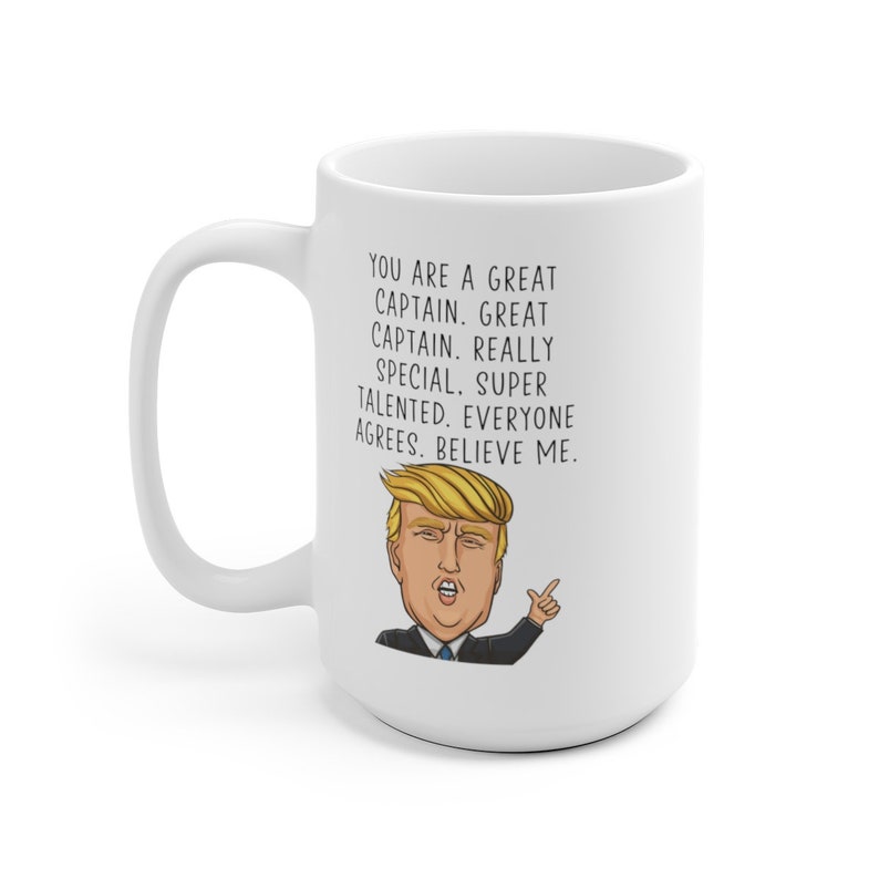 Puede incluir: Taza de caf&eacute; de cer&aacute;mica blanca con una ilustraci&oacute;n en blanco y negro de un hombre con cabello rubio y corbata roja. El texto en la taza dice "You are a great captain. Great captain. Really special, super talented. Everyone agrees. Believe me."