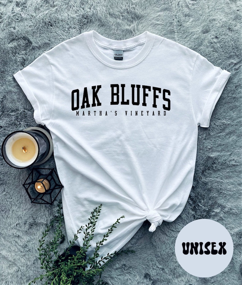 May include: White unisex t-shirt with black text that reads "Oak Bluffs Martha's Vineyard".
