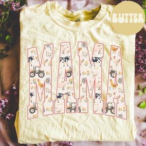 A yellow t-shirt with the word "MAMA" printed on it, surrounded by various farm-themed illustrations such as tractors, animals, and flowers.
