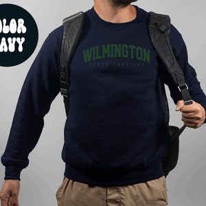May include: Navy blue sweatshirt with the text "WILMINGTON NORTH CAROLINA" in green.