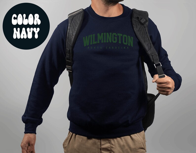 May include: Navy blue sweatshirt with the text "WILMINGTON NORTH CAROLINA" in green.