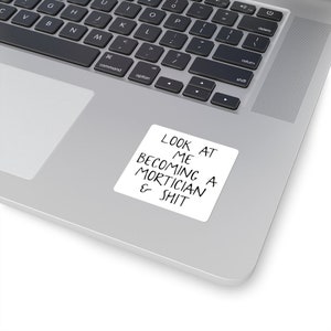 May include: A white sticker with black text that reads "LOOK AT ME BECOMING A MORTICIAN & SHIT".