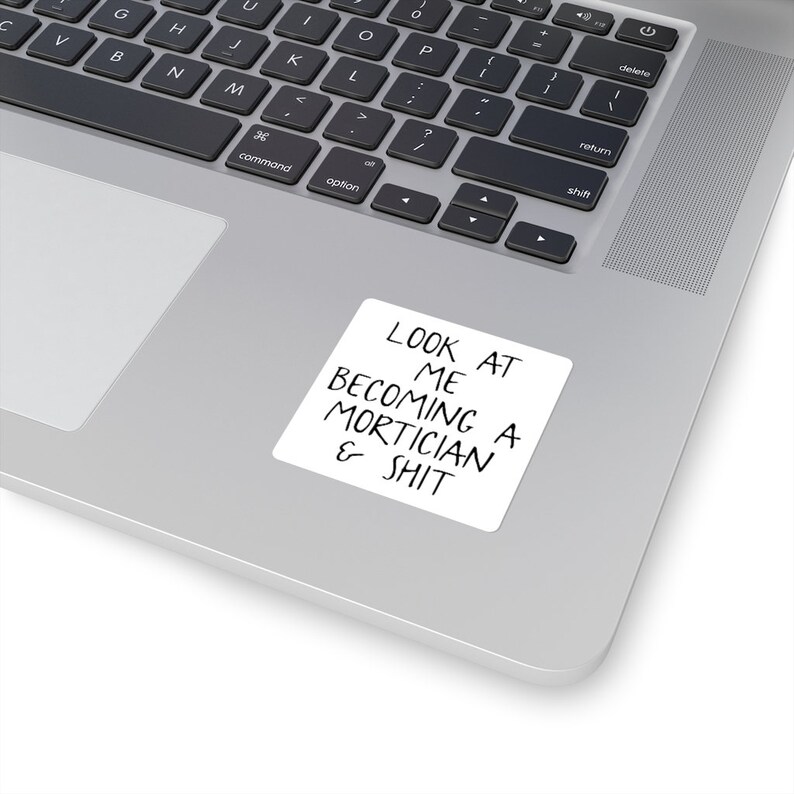 May include: A white sticker with black text that reads "LOOK AT ME BECOMING A MORTICIAN & SHIT".