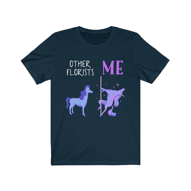 May include: A navy blue t-shirt with the text "Other Florists" and a unicorn with a flower crown. The text "ME" is next to the unicorn, which is holding a pole.