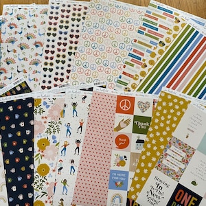 May include: A collection of 16 patterned scrapbook paper sheets featuring various designs, including peace signs, rainbows, flowers, sunglasses, and coffee cups. The paper is printed on a white background with colorful accents.