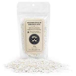 May include: A clear plastic bag filled with white meerschaum granules, with a small pile of granules in front. The bag has a label with text that reads "Meerschaum Granulate" and other details. The product is 30 g.
