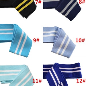 Op de afbeelding: Zes verschillende soorten gestreepte gebreide stof trim met twee strepen. De trim is verkrijgbaar in zwart met gele strepen, donkerblauw met witte strepen, lichtblauw met witte strepen, turquoise met witte strepen, donkerblauw met witte strepen en lichtblauw met witte strepen. De trim is gemarkeerd met de nummers 7 tot en met 12.