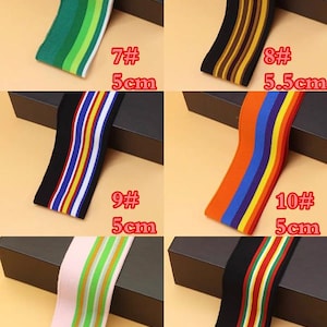 May include: Six different striped elastic bands in various colors, including green, brown, orange, black, pink, and red. The bands are 5 cm wide and are labeled with numbers 7 through 12.