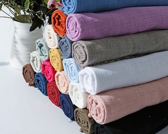 May include: A stack of 18 rolled fabric swatches in various colors, including blue, purple, gray, white, pink, brown, and black. The fabric is a soft, textured linen blend.