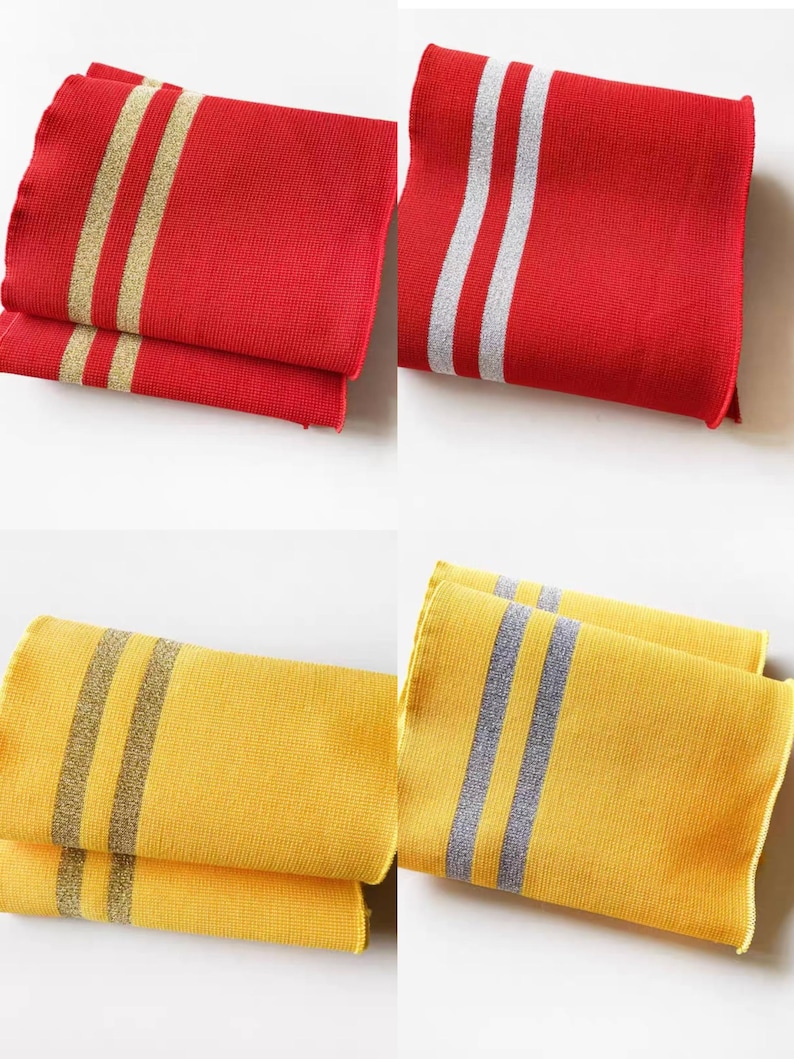 May include: Folded red and yellow cloth napkins with striped designs. The red napkins have gold and silver stripes, while the yellow napkins feature gray stripes. The napkins are neatly stacked, showcasing their texture and color variations.