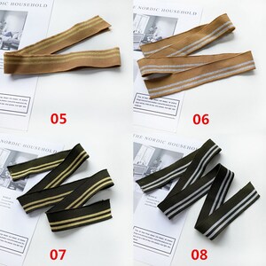 May include: Four different types of elastic ribbon with two stripes. The ribbons are brown with silver stripes, brown with gold stripes, green with gold stripes, and green with silver stripes. The ribbons are labeled with numbers 05, 06, 07, and 08.