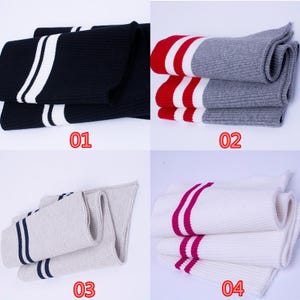 May include: Four pairs of folded socks with striped designs. The socks are in various colors: navy blue with white stripes, red with white stripes and gray, beige with navy stripes, and white with pink stripes. The numbers 01, 02, 03, and 04 are printed on the image.