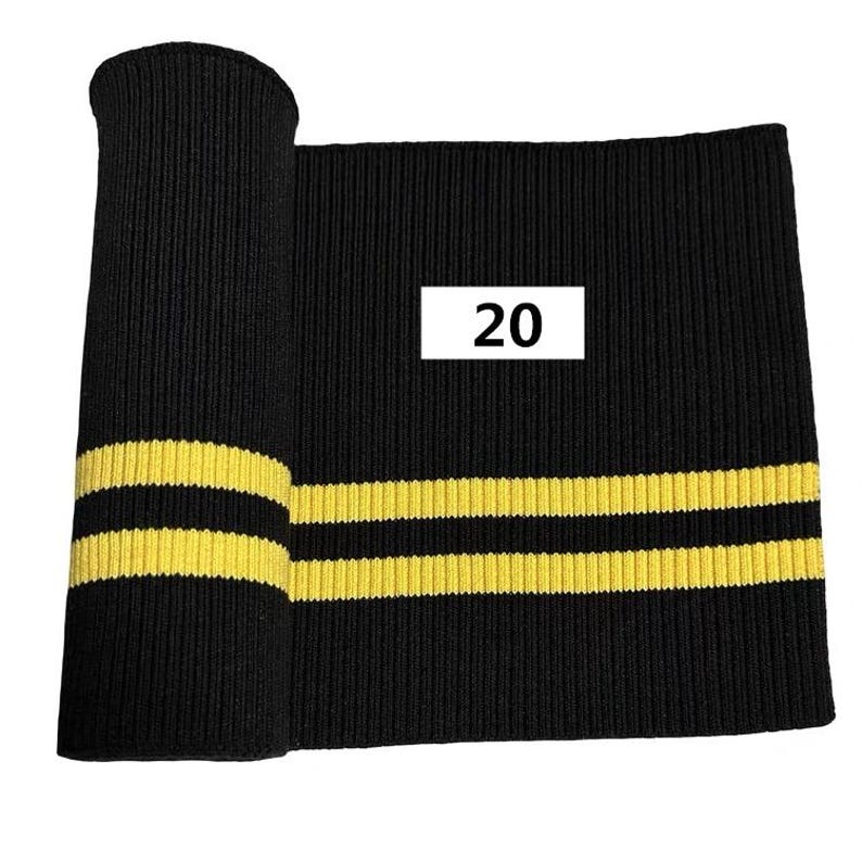 Puede incluir: Tejido de punto de canal&eacute; negro con dos rayas amarillas. El tejido est&aacute; etiquetado con "20".