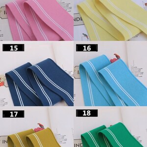 May include: Six samples of elastic trim with white stripes. The colors are pink, yellow, navy blue, light blue, mustard yellow, and green.
