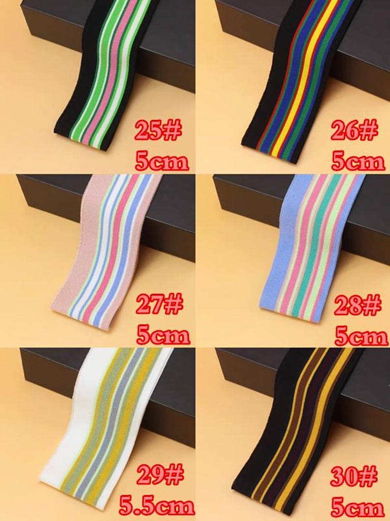 May include: Six different striped elastic bands in various colors, including black, white, green, pink, blue, and yellow. The bands are 5 cm wide and are labeled with numbers 25 through 30.