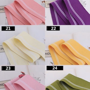 May include: Four different colors of elastic trim with white stripes. The colors are pink, purple, yellow, and green. The trim is approximately 1 inch wide.