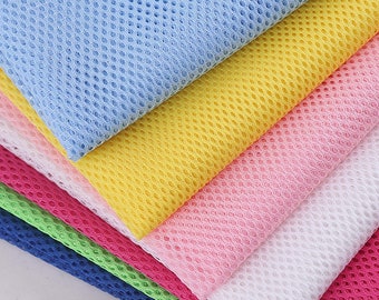 May include: A stack of six mesh fabric swatches in various colors, including light blue, yellow, pink, white, green, and pink. The fabric has a small, evenly spaced, diamond-shaped pattern.