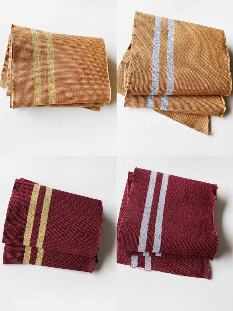 May include: Four folded rectangular scarves. Two are tan with gold stripes, and two are tan with silver stripes. The other two are burgundy with gold stripes, and burgundy with silver stripes. All have a textured weave.
