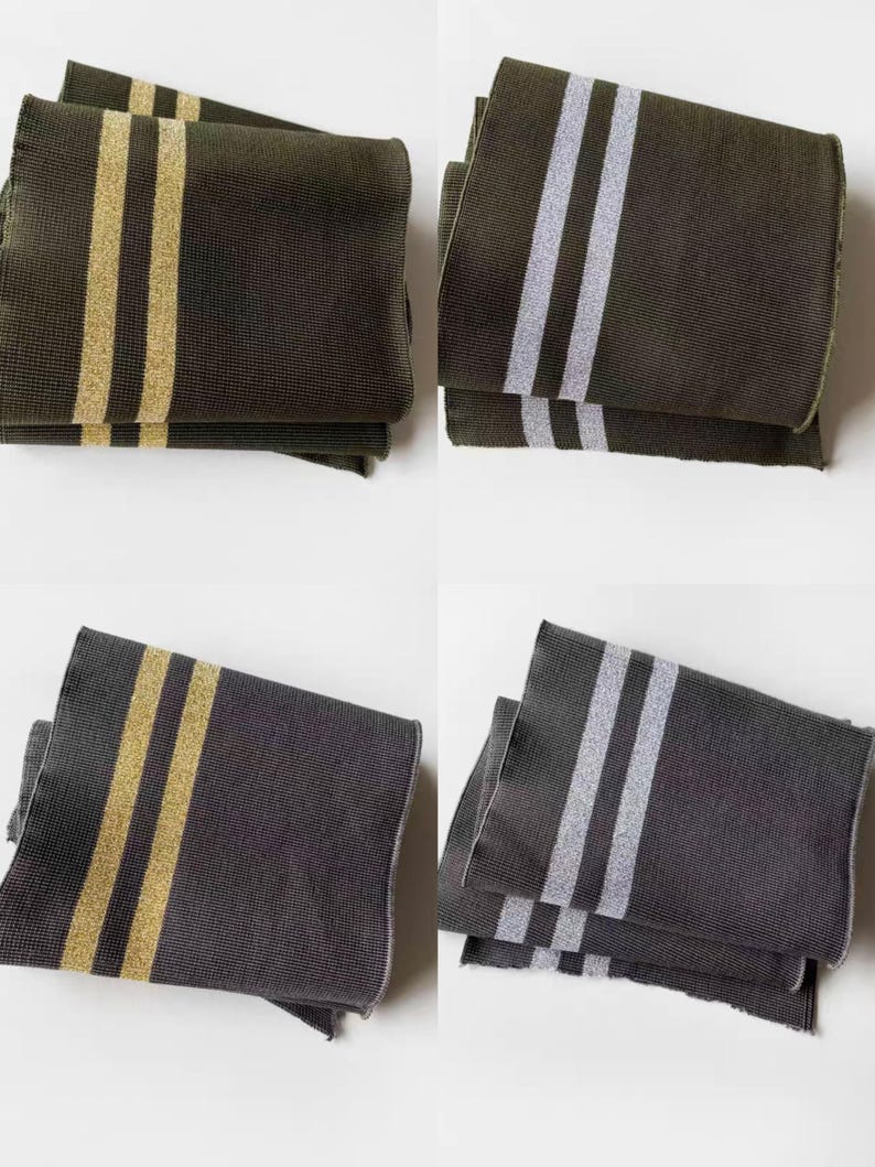 May include: Four folded scarves in shades of olive green and charcoal gray. Two scarves have gold stripes, and two have silver stripes. The scarves are made of a textured fabric and are neatly folded.