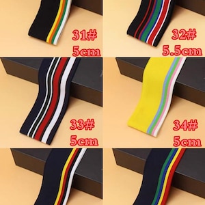 May include: Six different types of elastic trim with colorful stripes. The trim is 5 cm wide, except for the second trim which is 5.5 cm wide. The trim is available in black, yellow, white, and navy blue.