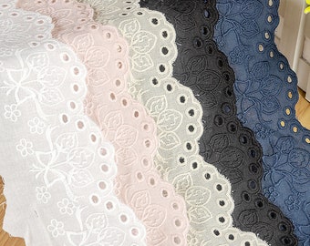 May include: Five different colours of cotton lace trim with a scalloped edge and eyelet details. The colours are white, light pink, light grey, black, and navy blue.