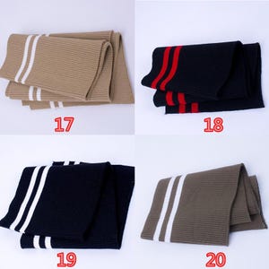 May include: Four folded scarves in various colors. Top left is tan with two white stripes. Top right is black with two red stripes. Bottom left is black with two white stripes. Bottom right is olive green with two white stripes. Numbers 17, 18, 19, and 20 are visible.