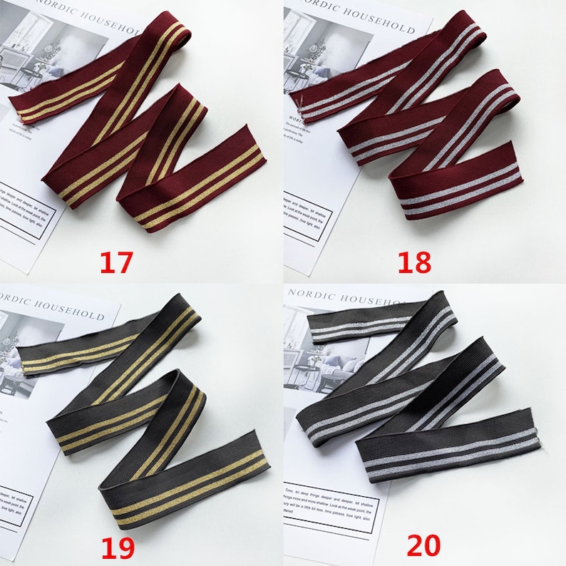 May include: Four different types of elastic trim with two stripes. The trim is available in burgundy with gold stripes, gray with silver stripes, dark gray with gold stripes, and black with silver stripes. The trim is labeled with numbers 17, 18, 19, and 20.