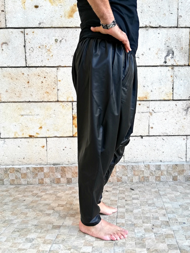 May include: Black leather pants with a loose, flowing fit. The pants have a wide leg and a low rise.
