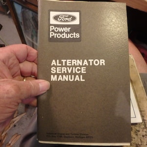 May include: A brown manual with the title "Ford Power Products Alternator Service Manual" printed in white. The manual is for the Industrial Engine and Turbine Division, P.O. Box 1798, Dearborn, Michigan 48121.