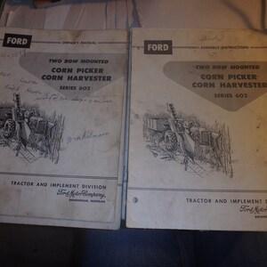 May include: Two black and white manuals for a Ford two-row mounted corn picker and corn harvester, series 602. The manuals are titled "Owner's Manual" and "Assembly Instructions".