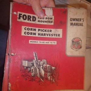 May include: A red and white Ford corn picker and corn harvester owner's manual. The cover features a black and white illustration of a two-row mounted corn picker in a field of corn. The manual is for models 16-66 and 16-76.
