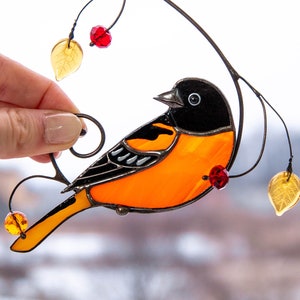 orange stained glass bird suncatcher with red berries and yellow leaves