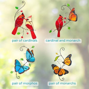 Stained glass suncatchers showing different designs: pair of cardinals, cardinal with monarch butterfly, pair of morpho butterflies, and pair of monarch butterflies.
